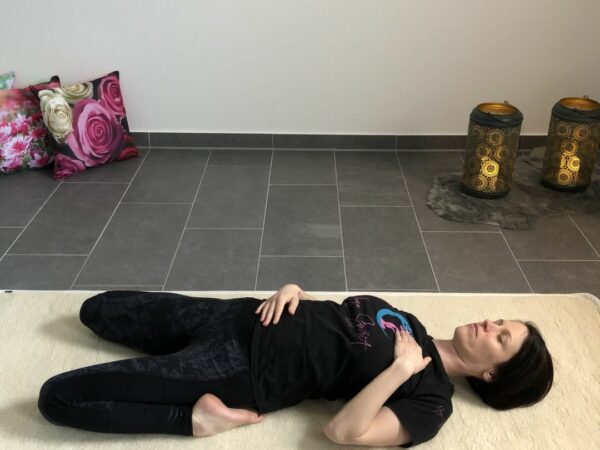 Yin Yoga Position liegend Hand auf Bauch und Herz